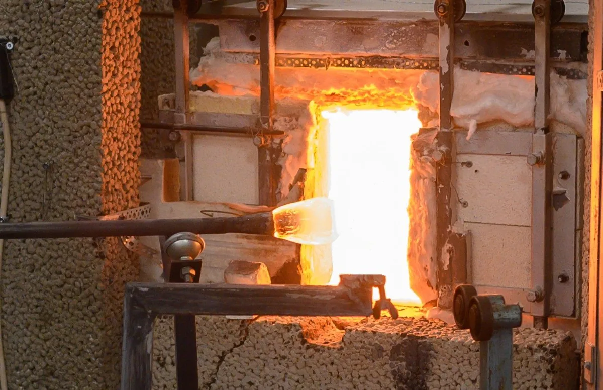 Glödande glas framför den öppna glasugnen